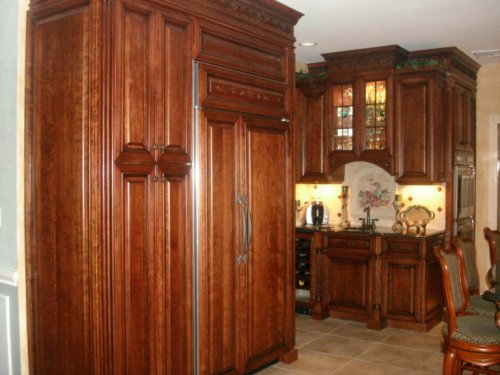 pantry and refrigerator with wet bar in background